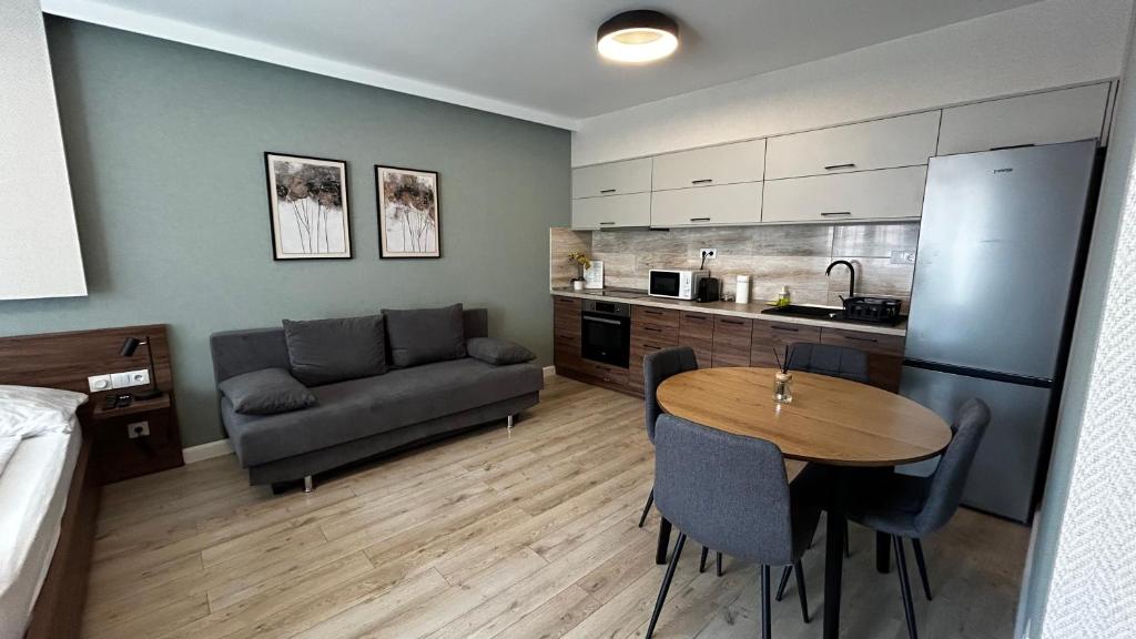 a kitchen and living room with a table and a couch at Hatvan Central Apartment in Debrecen