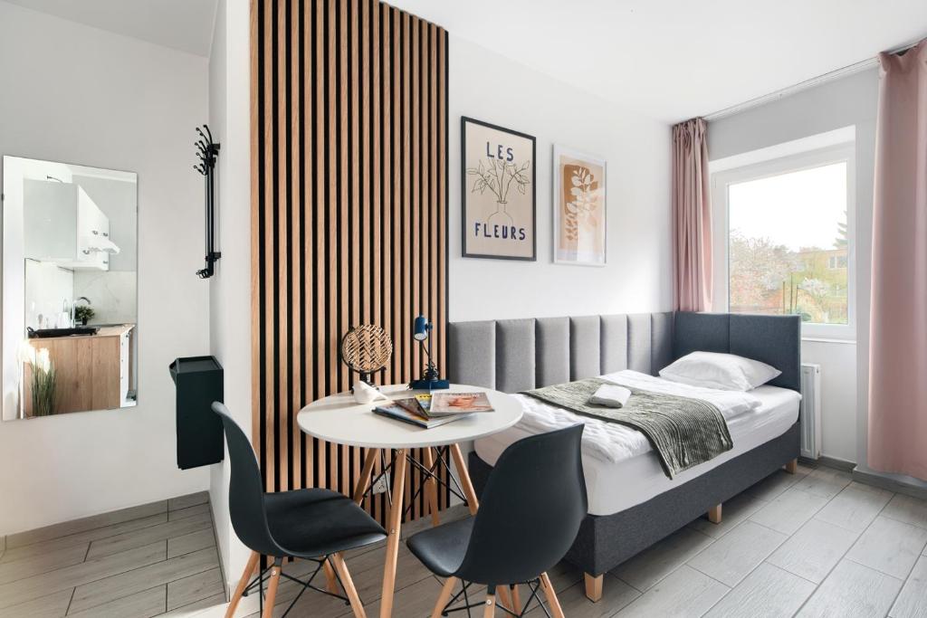 a bedroom with a bed and a table and chairs at Mini Apartamenty Poznań in Poznań