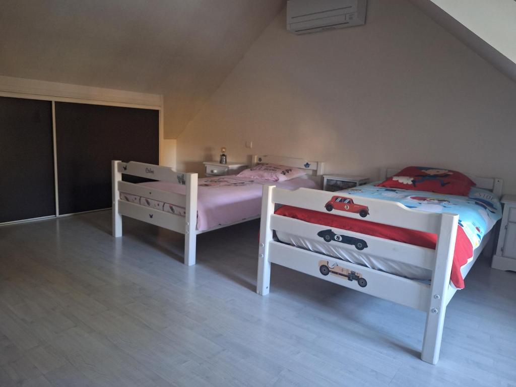 a bedroom with two beds in a attic at Chambres à 10 min du circuit des 24h en campagne in Guécélard