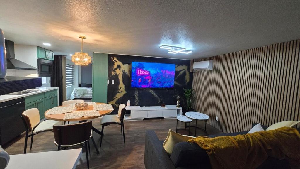 a living room with a table and a tv on a wall at Cozy Private Retreat in Phoenix