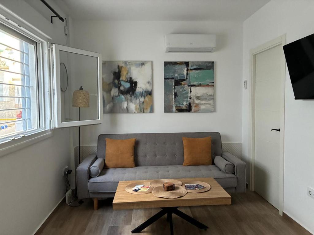 a living room with a couch and a table at Nuestro lugar feliz Apartamento Barbate - Patio ducha exterior in Barbate