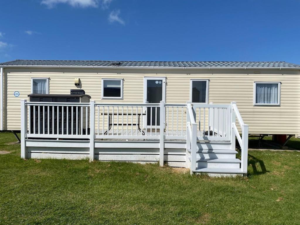 a house with a white fence and a porch at Faville in Selsey