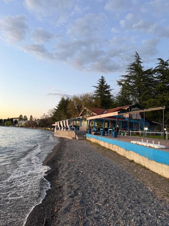 a row of buildings on a beach next to the water at Villa art colony in Ohrid