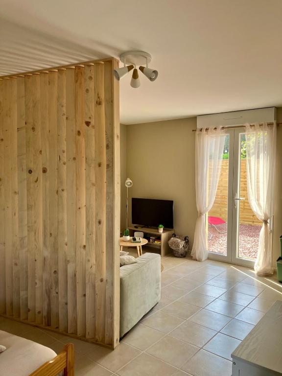 a living room with a large wooden wall at Abri 82 in Picauville