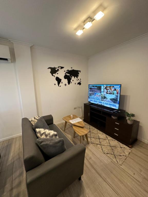 a living room with a couch and a flat screen tv at NGL - Departamento temporal con cochera in Santa Fe