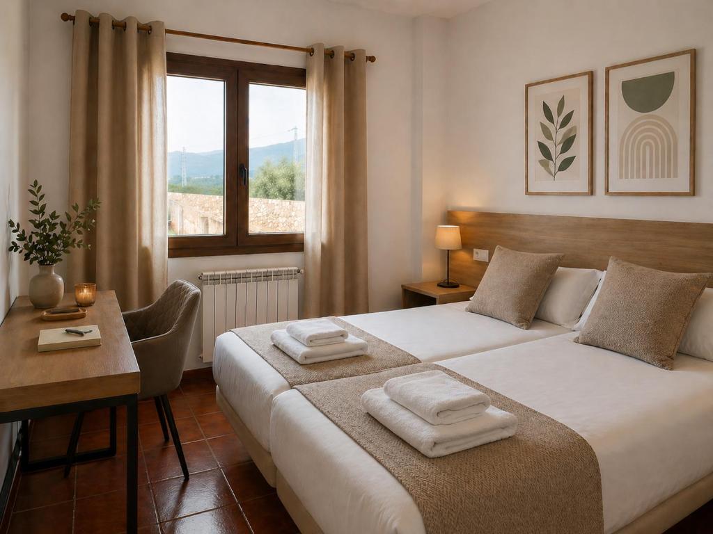 a bedroom with a bed and a desk and a window at L'Albea Hotel Rural in Vall dʼAlba