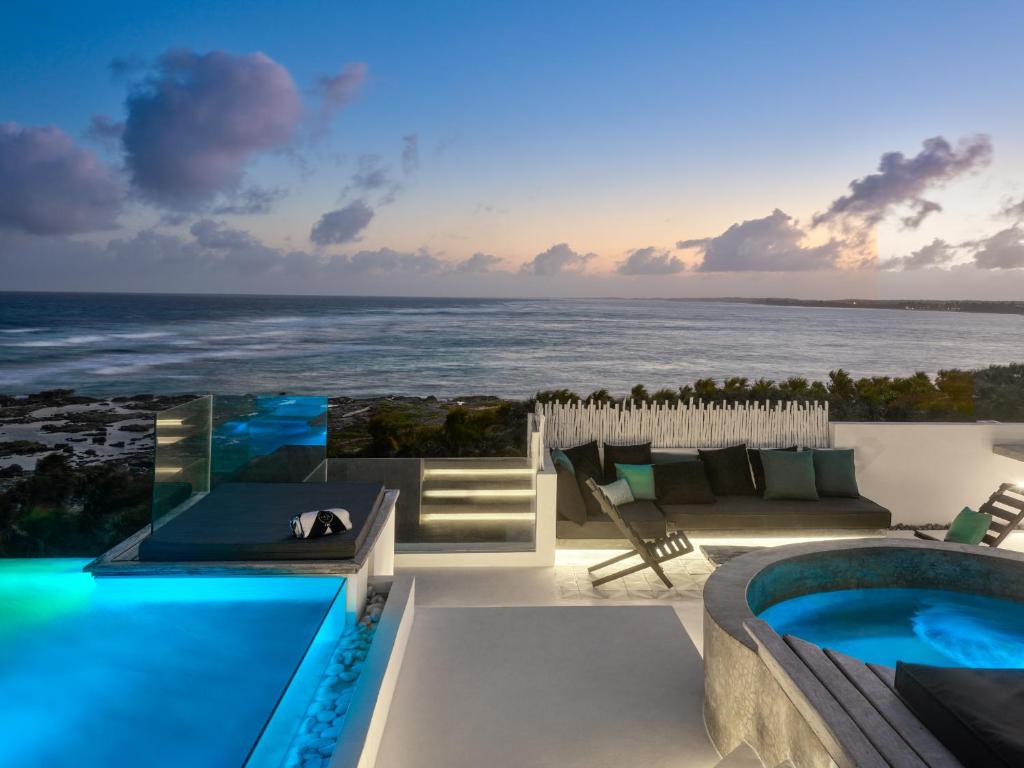 a villa with a swimming pool and a view of the ocean at TULUM Beachfront Villa Kiin in Tulum