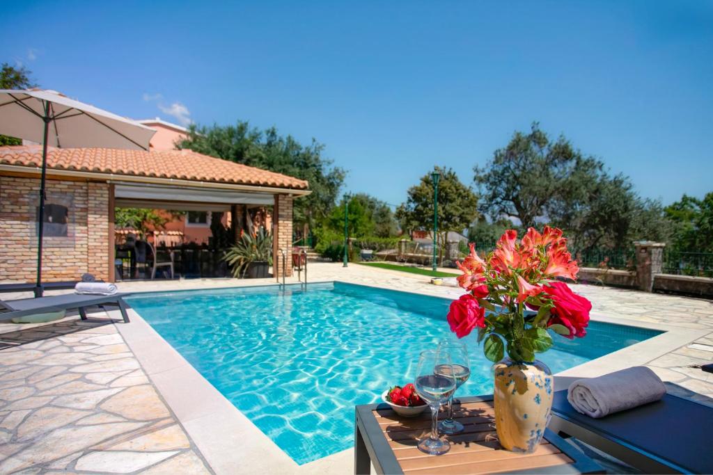a swimming pool with a vase of flowers on a table at Villa Marifei in Kato Korakiana