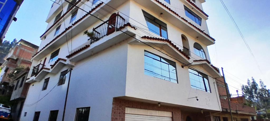 a white building with windows and a balcony at Hotel Selena 1 in Huaraz