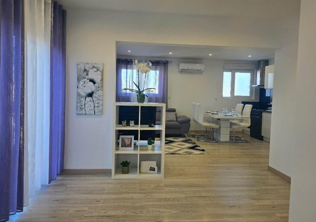 a living room with a table and a living room with a room at DIAG Appartement 3 Chambres in Commequiers