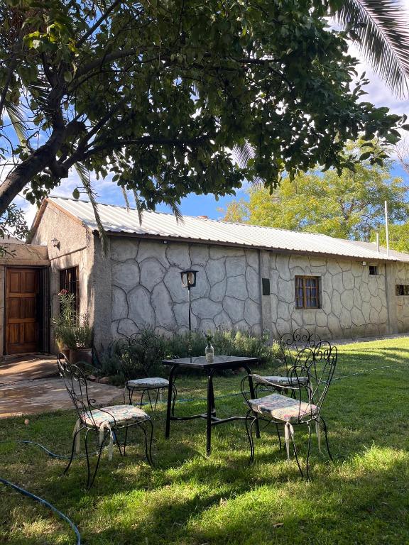 a picnic table and chairs in front of a building at Rincón Las Hiedras in Chacras de Coria