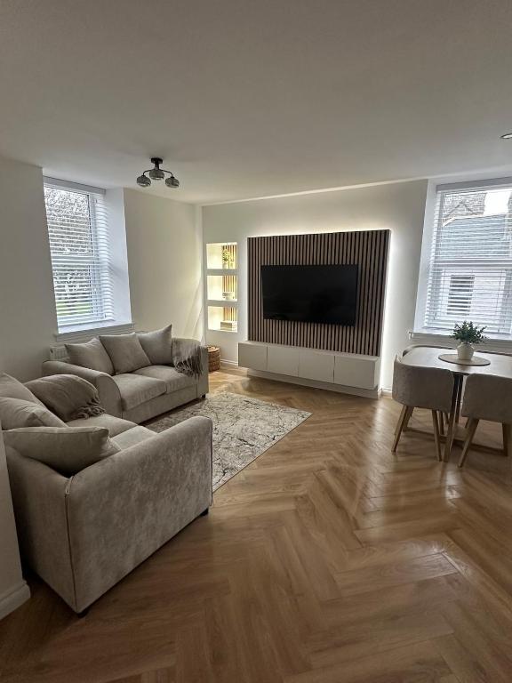 a living room with two couches and a television at Modern Two- bedroomed flat in Wick, Caithness in Wick