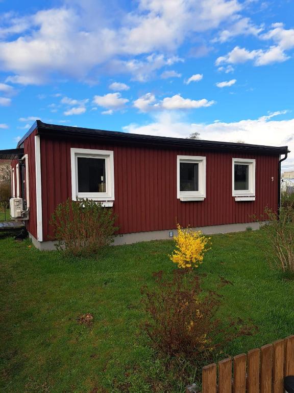 ein rotes Haus mit weißen Fenstern in einem Hof in der Unterkunft Öjavad in Svängsta