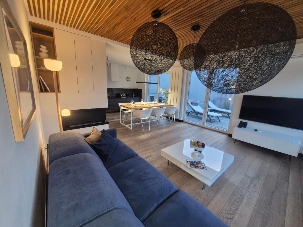 a living room with a blue couch and a table at LakeView 59 Lemon Resort Spa in Gródek Nad Dunajcem