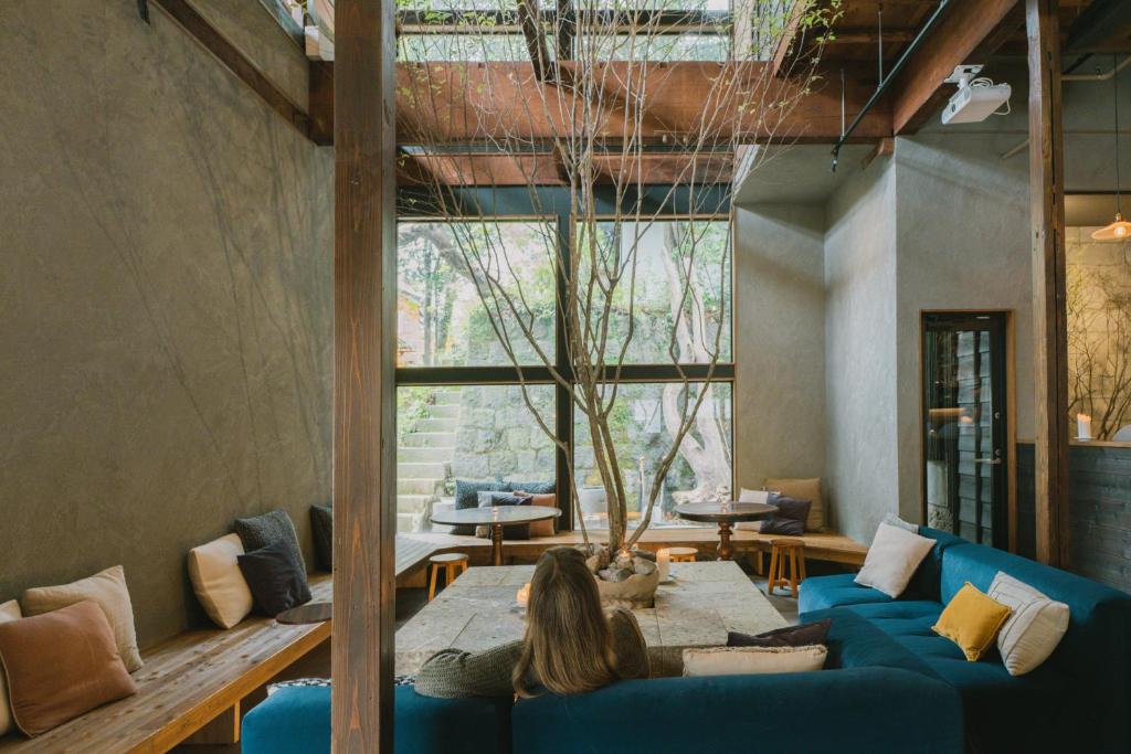 a woman sitting on a couch in a living room at RoheN HAKONEYUMOTO in Hakone