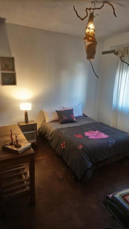 a bedroom with a bed and a table and a lamp at Casa JINDRA in Puerto Madryn