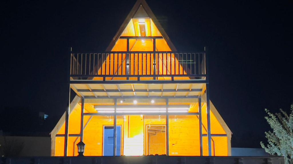 a yellow building with a balcony on top of it at Al Joud Chalet Private Jacuzzi & BBQ Ajloun in Ajloun