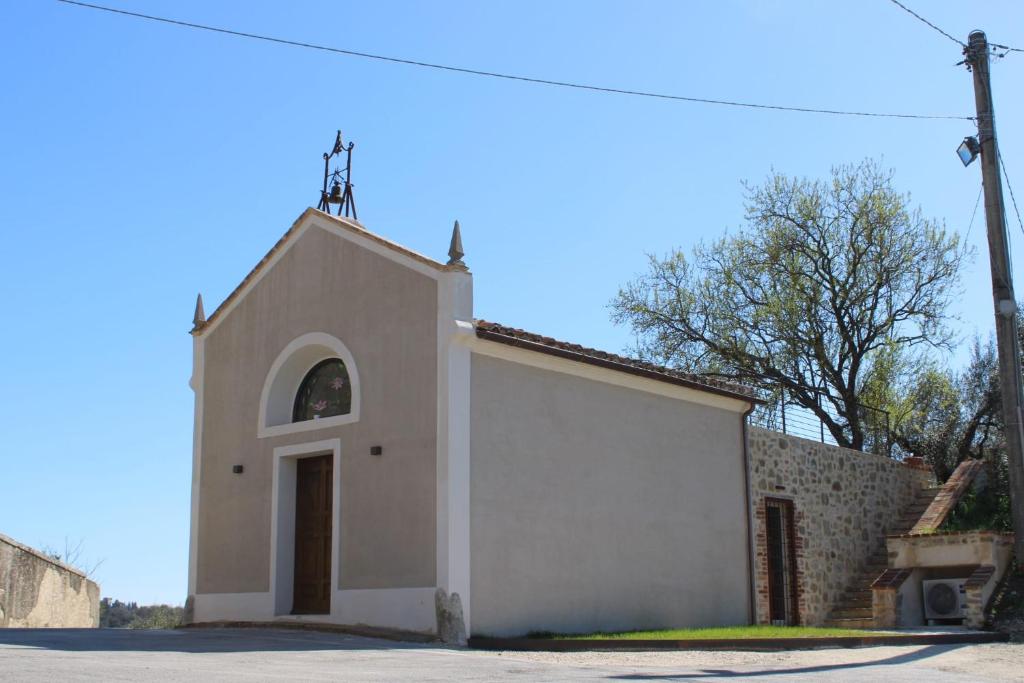 a small white church with a cross on top at Chiesina di Montesperello in Pantanella