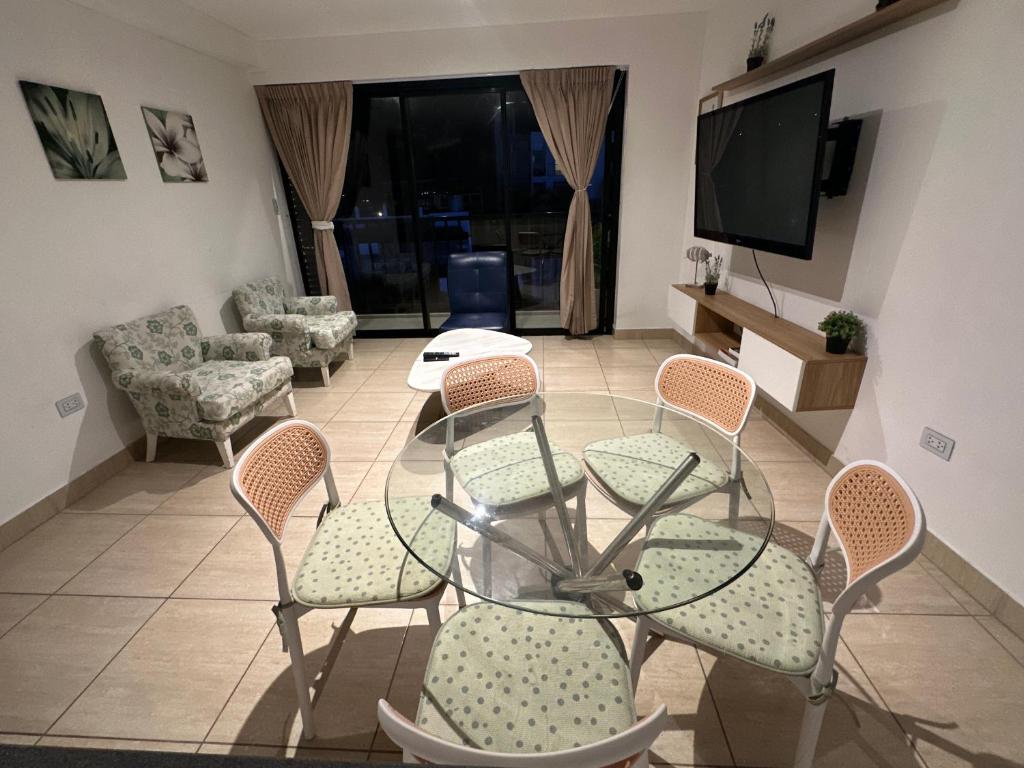 a living room with a glass table and chairs at Lindo Departamento con Terraza Vista al Mar in Pimentel