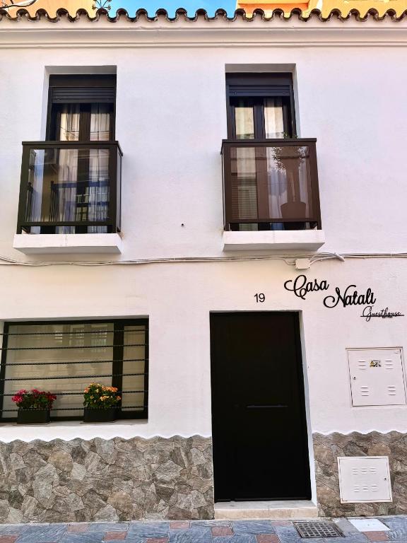 a white building with two windows and a door at Casa Natali in Fuengirola