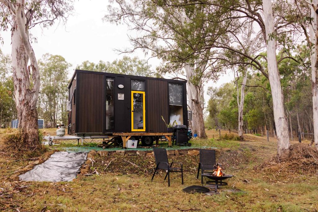 a tiny house sitting on a trailer in the woods at The Tiny Chalet by Tiny Away in Bromfleet