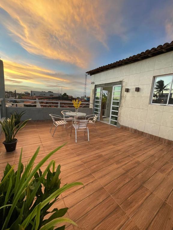 a patio with a table and chairs on a deck at New House Temporada in João Pessoa