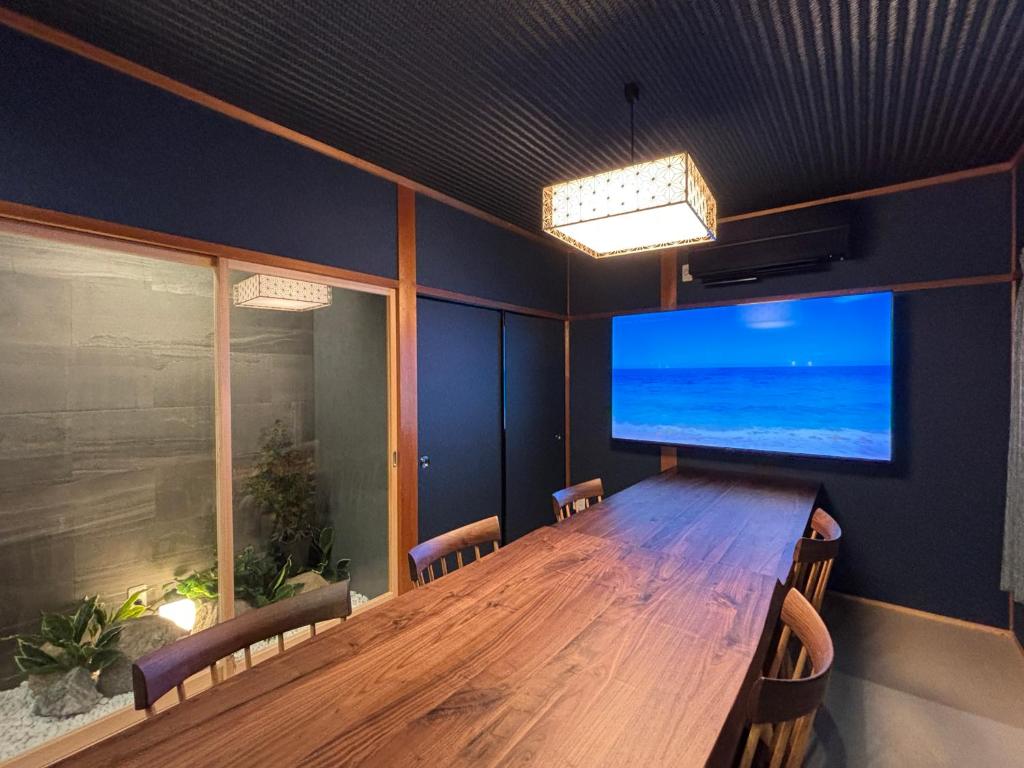 a conference room with a wooden table and a large screen television at 凪 nagi Awaji in Awaji