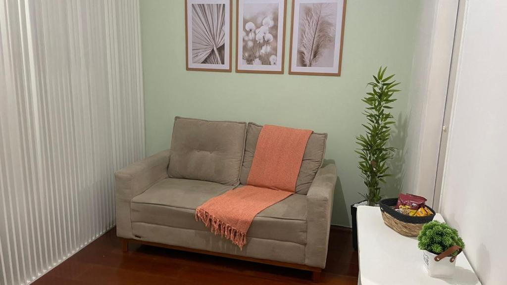 a chair with an orange blanket on it in a living room at Ap Aconchego in Campinas
