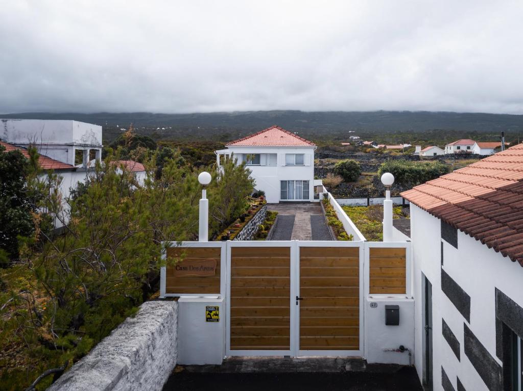 a white house with wooden doors in a yard at Casa Dos Arcos Oceanfront Apartments in Arcos