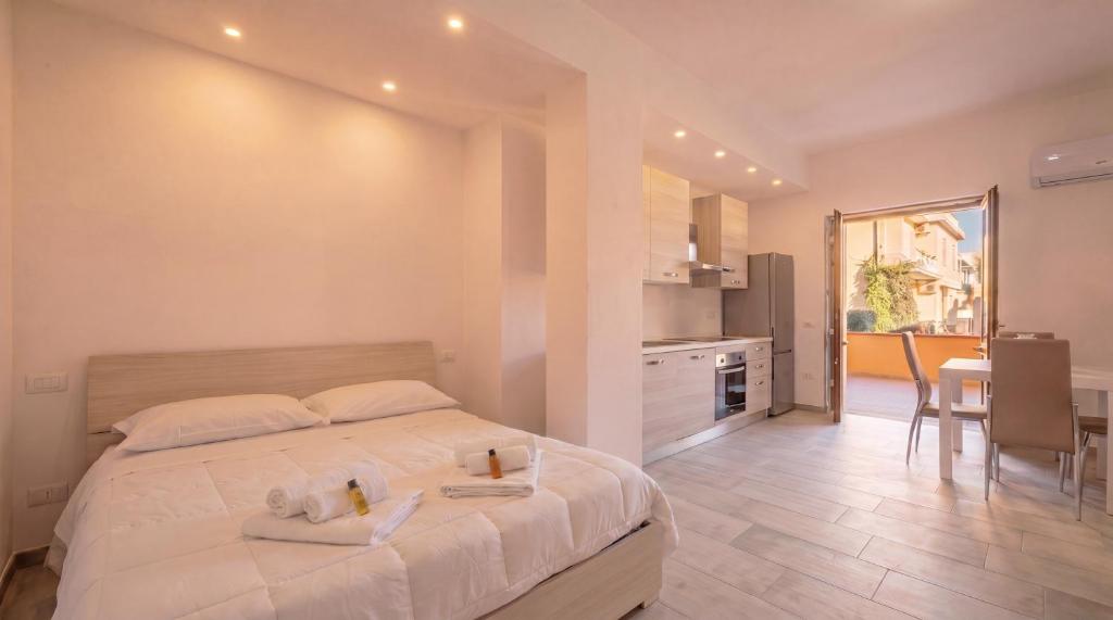 a bedroom with a bed and a kitchen with a table at Dimoras Central Studio 4 Guests Parking in Olbia