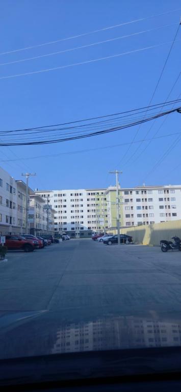a parking lot with a large building in the background at Plumera Mactan Condominium near Airport in Bankal