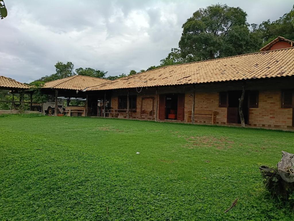 a building with a grass yard in front of it at Sítio dos Nogueira in Pará de Minas