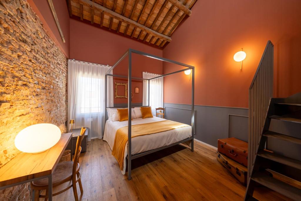 a bedroom with a bed and a brick wall at Spaccavento Boutique Rooms in Chioggia