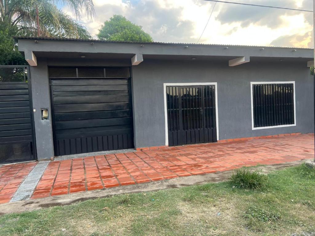 a house with two garage doors and a brick driveway at Roli in Clorinda