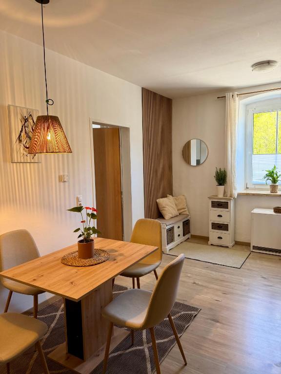a living room with a wooden table and chairs at Traunzeit Apartment in Ebensee