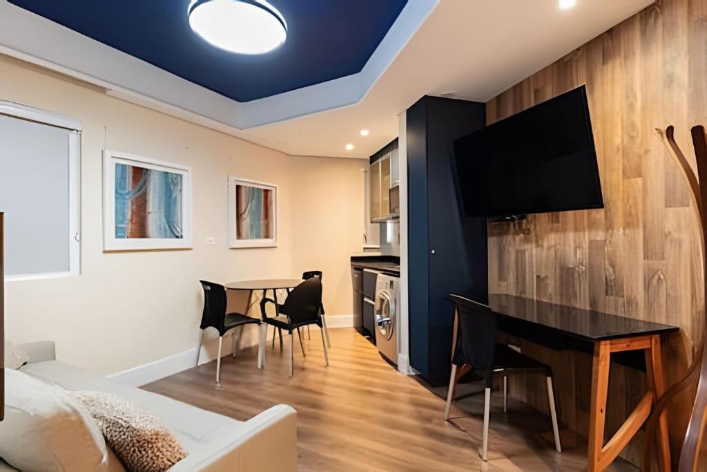a living room with a table and a tv on a wall at Flat Hotel Sena Madureira_Ibirapuera (Apto 708) in São Paulo