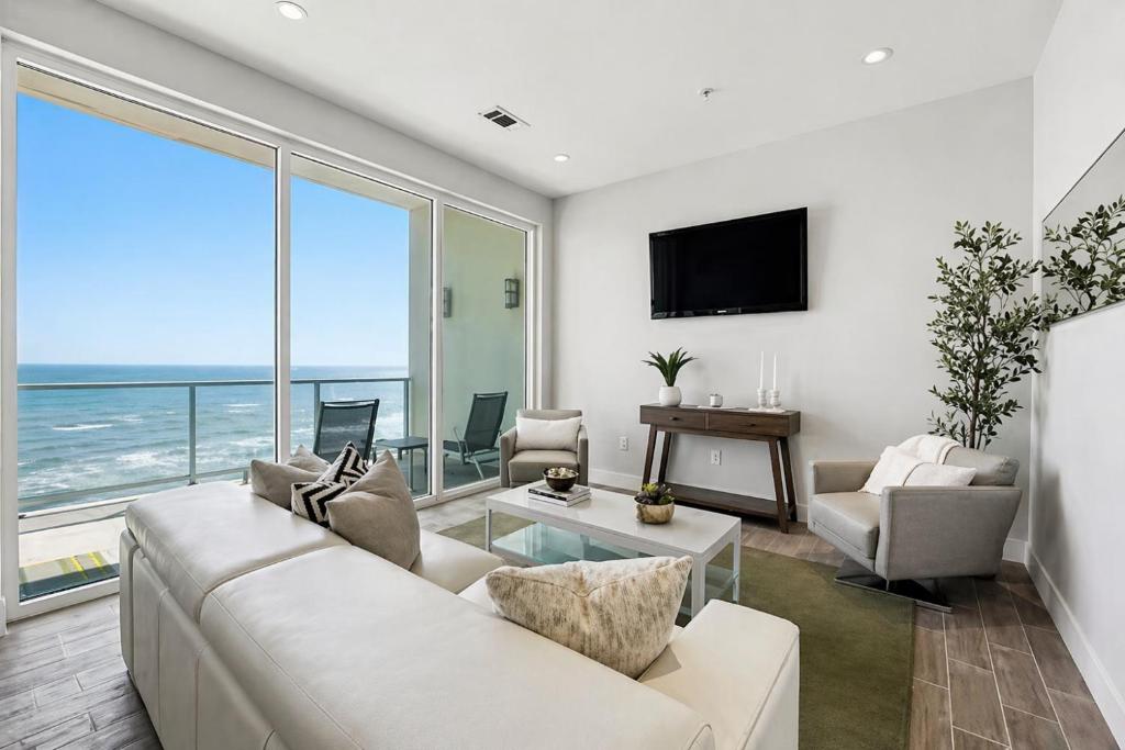 a living room with a white couch and a large window at Diamond Beach in Galveston