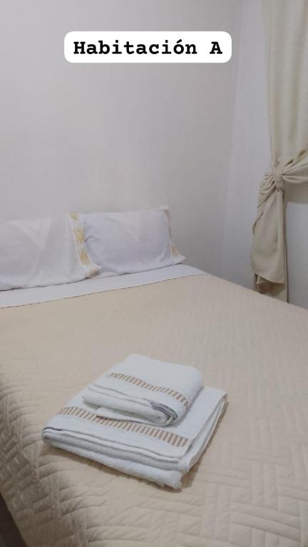 two folded towels sitting on top of a white bed at Lo de Dolly in Tartagal