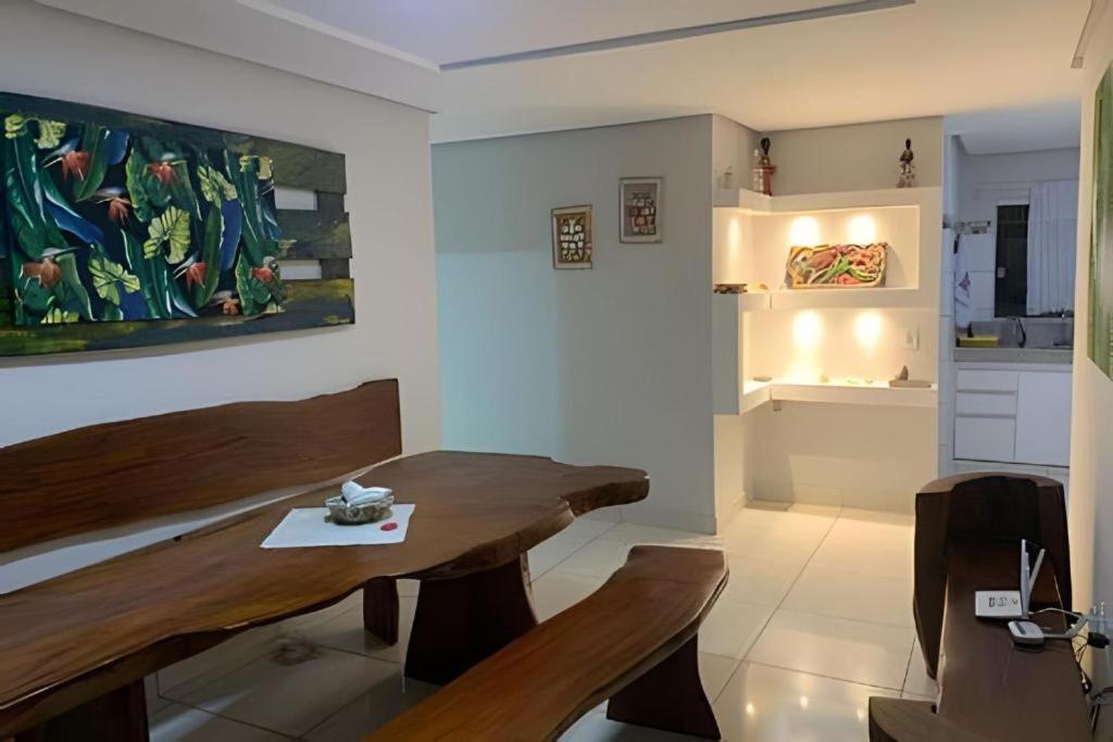 a dining room with a wooden table and chairs at Residencial Villa dos Corais - Staybeach in Porto Seguro