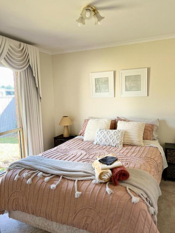 a bedroom with a bed with blankets and a window at Hannahs Haven in Traralgon