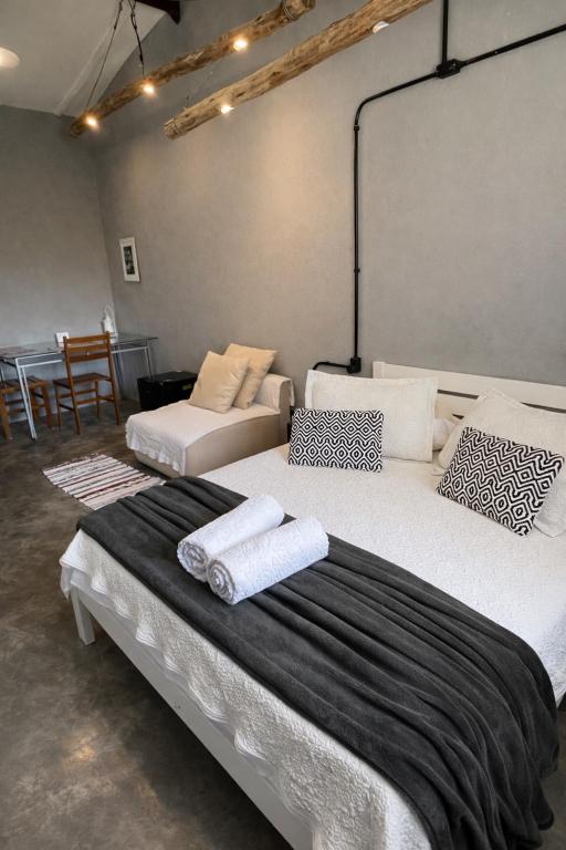 two large beds in a room with a table at Refúgio Pauapique - Suítes com café da manhã, ar condicionado e frigobar à 900 metros da Rota do Vinho in São Roque