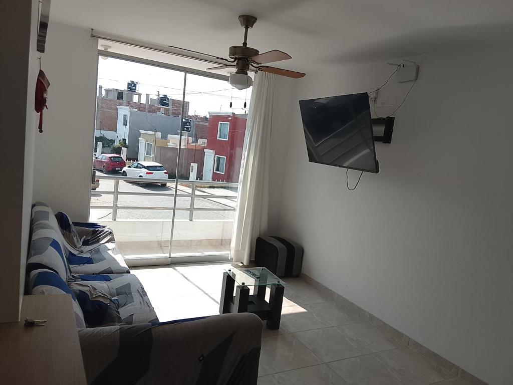 a living room with a couch and a flat screen tv at departamento familiar privado trujillo huanchaco in Huanchaco