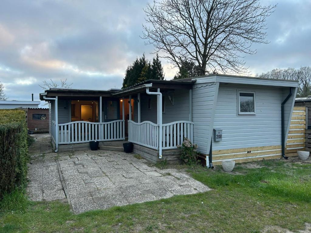 a small house with a porch and a yard at 208 Chalet Bosrust in Anloo