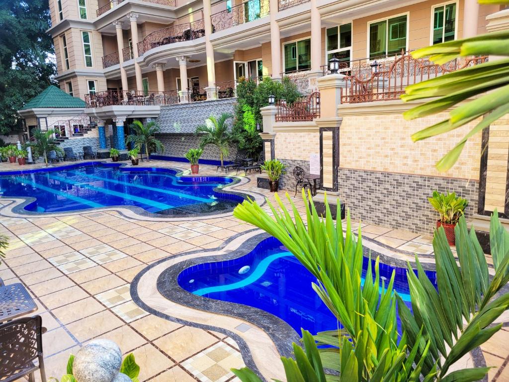 an image of a swimming pool in front of a building at Fountain Palace Hotel & Suites in Kampala