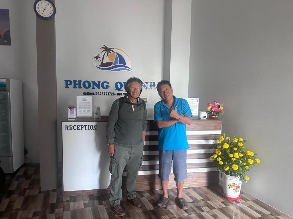 two men standing in front of a phone booth at Nhà Nghỉ Phong Quỳnh - Đảo Phú Quý in Cu Lao Thu