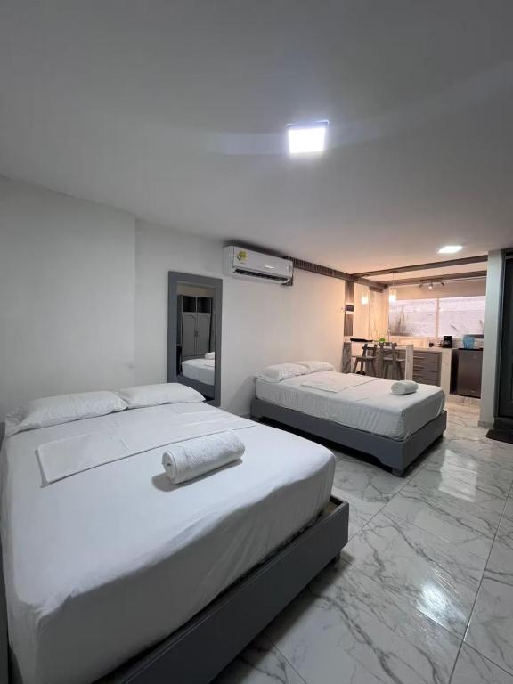 two beds in a room with a room with at Apartamento Centro Histórico Cartagena in Cartagena de Indias