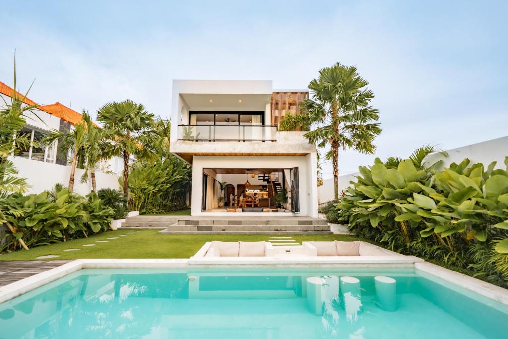 a house with a swimming pool in front of a house at Botanique Villa & Studio in Tanah Lot