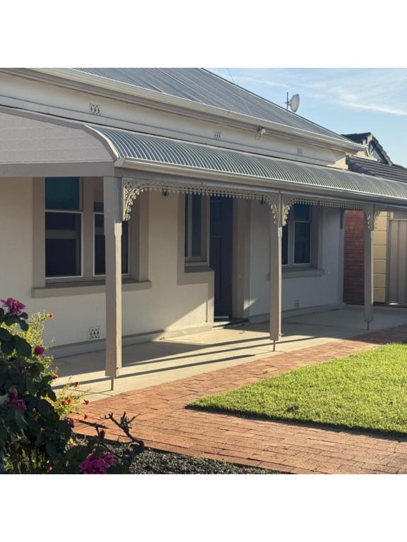 a white house with a porch with a roof at Perrys Place in Nuriootpa