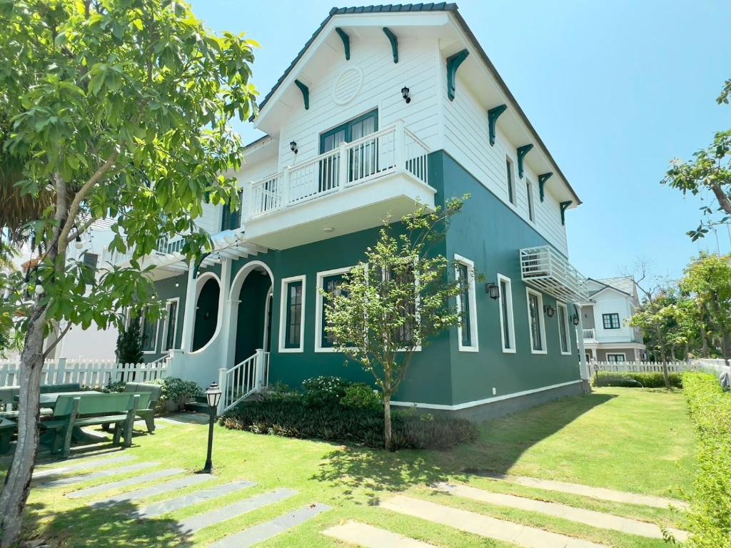 a blue and white house with a picnic table in the yard at Solara Coast Villa in Tiến Thành