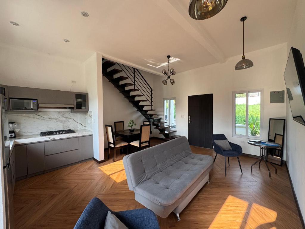 a living room with a couch and a kitchen and a staircase at Casa Escondida in San Felipe